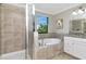 Bathroom boasts a tiled shower, soaking tub, and white cabinets, creating a spa-like atmosphere at 18013 Polo Trl, Bradenton, FL 34211