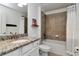 Bathroom featuring a granite countertop vanity, white cabinets, and a tiled shower and tub at 18013 Polo Trl, Bradenton, FL 34211