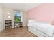 Bright bedroom with wood floors, desk, chair and a pink accent wall, perfect for relaxation at 18013 Polo Trl, Bradenton, FL 34211