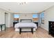 Bright bedroom showcasing wood floors, two bedside tables and bench, providing a comfortable space at 18013 Polo Trl, Bradenton, FL 34211