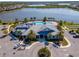 Stunning aerial view of the clubhouse featuring a resort-style pool and lounge area with serene lakeside views at 18013 Polo Trl, Bradenton, FL 34211