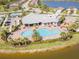 Community aerial showcasing the pool, clubhouse, playground, and surrounding lush landscaping with lake view at 18013 Polo Trl, Bradenton, FL 34211