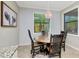 Cozy dining area boasts a wooden table, four chairs, a chandelier, and a window with a view at 18013 Polo Trl, Bradenton, FL 34211