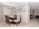 Open dining room features neutral walls, hardwood flooring, and a decorative gallery wall with natural light at 18013 Polo Trl, Bradenton, FL 34211