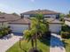 Charming two-story home featuring a brick paved driveway, two-car garage, and lush landscaping at 18013 Polo Trl, Bradenton, FL 34211