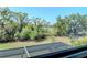 A screened lanai view of a lake and lush landscape, providing a tranquil outdoor space at 18013 Polo Trl, Bradenton, FL 34211