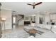 Spacious open-concept living room with a large sectional, ceiling fan, and seamless flow into the dining area at 18013 Polo Trl, Bradenton, FL 34211