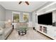 Open concept living room with a large entertainment center, neutral walls and a modern ceiling fan at 18013 Polo Trl, Bradenton, FL 34211