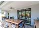 Outdoor dining area on the patio with a ceiling fan and sliding glass doors leading inside at 18013 Polo Trl, Bradenton, FL 34211