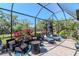 Screened patio featuring stone flooring, lounge chairs, and lush tropical landscaping creates an outdoor oasis at 18013 Polo Trl, Bradenton, FL 34211