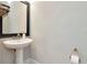 Small powder room features a pedestal sink, framed mirror, and a decorative wall treatment at 18013 Polo Trl, Bradenton, FL 34211
