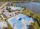 Aerial view of tennis courts in a community featuring a clubhouse, pool, and scenic lake views at 18013 Polo Trl, Bradenton, FL 34211