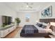 Comfortable main bedroom with a ceiling fan, a plush bed, and sleek entertainment center, perfect for relaxation at 2364 Carpenter Ln, North Port, FL 34286