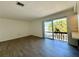Bright living room with wood-look flooring, natural lighting and a sliding glass door to a balcony at 2632 Hidden Lake N Dr # E, Sarasota, FL 34237