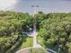 Aerial view showcasing the community's serene park, lush surroundings, and waterfront access with a pier at 2908 Fiddlers Bnd, Palmetto, FL 34221