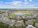 An aerial view of a tranquil neighborhood featuring a pond, golf course, and well-maintained homes under a partly cloudy sky at 2908 Fiddlers Bnd, Palmetto, FL 34221