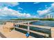 Scenic dock view featuring a bench, calm waters, and distant building under a bright sky at 2908 Fiddlers Bnd, Palmetto, FL 34221
