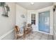 A cozy front porch with a table, chairs, and a charming blue door that welcomes guests at 2908 Fiddlers Bnd, Palmetto, FL 34221