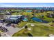Scenic aerial view of a golf course and clubhouse, complete with a pool and surrounding lush landscaping at 2908 Fiddlers Bnd, Palmetto, FL 34221