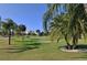 Lush green golf course scene with palm trees and golfers in the background on a sunny day at 2908 Fiddlers Bnd, Palmetto, FL 34221