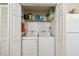 Bright laundry area features a side-by-side washer and dryer and extra storage shelves in a closet at 2908 Fiddlers Bnd, Palmetto, FL 34221