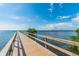 Picturesque wooden pier extending into the water, under a clear blue sky with scattered clouds at 2908 Fiddlers Bnd, Palmetto, FL 34221