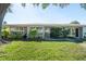 Home exterior view with wall of windows and beautiful manicured lawn at 3289 Fairhaven Ln # 112, Sarasota, FL 34239