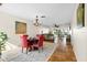 Open concept dining area with red chairs and view into the living room and access to outdoor seating at 3289 Fairhaven Ln # 112, Sarasota, FL 34239
