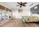 Bright main bedroom with french doors and bamboo blinds leading to outdoor living area and light colored wood floors at 3289 Fairhaven Ln # 112, Sarasota, FL 34239