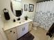 Well-lit bathroom featuring a vanity with an oval mirror, stylish fixtures, and a patterned shower curtain at 3500 El Conquistador Pkwy # 357, Bradenton, FL 34210