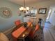 Dining room area with kitchen view featuring wood table and colorful rug at 3500 El Conquistador Pkwy # 357, Bradenton, FL 34210