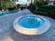 A close-up of the tiled community hot tub, with the pool and seating visible in the background at 3500 El Conquistador Pkwy # 357, Bradenton, FL 34210