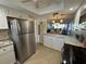Open concept kitchen with stainless steel refrigerator, white cabinets and granite countertops at 3500 El Conquistador Pkwy # 357, Bradenton, FL 34210