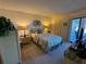 Cozy main bedroom with carpet, with comfortable queen bed, lamps on bedside tables, and access to outdoor balcony at 3500 El Conquistador Pkwy # 357, Bradenton, FL 34210
