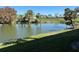 Scenic view of a pond surrounded by lush greenery and palm trees, reflecting the clear blue sky at 3500 El Conquistador Pkwy # 357, Bradenton, FL 34210