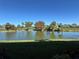 Picturesque pond reflecting the clear blue sky, surrounded by lush greenery, creating a peaceful setting at 3500 El Conquistador Pkwy # 357, Bradenton, FL 34210