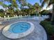Community pool with a hot tub, surrounded by lush landscaping and seating areas at 3500 El Conquistador Pkwy # 357, Bradenton, FL 34210