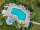 Aerial view of community pool and hot tub surrounded by lounge chairs and manicured landscaping at 3500 El Conquistador Pkwy # 357, Bradenton, FL 34210