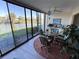 Bright sunroom with large windows showcasing a serene lake view and comfortable dining set at 3500 El Conquistador Pkwy # 357, Bradenton, FL 34210