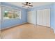 Bedroom with a large window, a ceiling fan, and double closets, providing ample natural light and storage at 3908 Panola Ln # 193, Sarasota, FL 34232