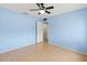 A simple bedroom with a ceiling fan, light blue walls, and a door leading to another room at 3908 Panola Ln # 193, Sarasota, FL 34232
