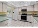 Modern kitchen features white appliances, yellow walls, updated countertop, and ample cabinet space at 3908 Panola Ln # 193, Sarasota, FL 34232
