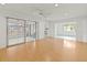 Open floor plan living room featuring light wood floors, ceiling fan, and sliding doors to lanai at 3908 Panola Ln # 193, Sarasota, FL 34232