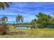 Scenic view of a tranquil pond with palm trees and lush landscaping, enhancing the community's charm at 3908 Panola Ln # 193, Sarasota, FL 34232