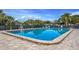 Community swimming pool with brick paver surround and lush tropical landscaping at 3908 Panola Ln # 193, Sarasota, FL 34232