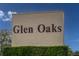Community sign for Glen Oaks featuring dark block lettering against a beige stucco background at 3908 Panola Ln # 193, Sarasota, FL 34232