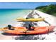Colorful Ocean Kayaks on a white sand beach with the ocean in the background at 3910 Cape Haze Dr, Rotonda West, FL 33947