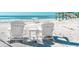 A beach scene with two white Adirondack chairs and a small table facing the ocean at 3910 Cape Haze Dr, Rotonda West, FL 33947