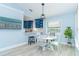 Cozy dining area adjacent to the kitchen, featuring a round table, modern lighting and a TV at 3910 Cape Haze Dr, Rotonda West, FL 33947