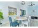 Bright dining area with white table, blue accent chairs, and a large window for natural light at 3910 Cape Haze Dr, Rotonda West, FL 33947
